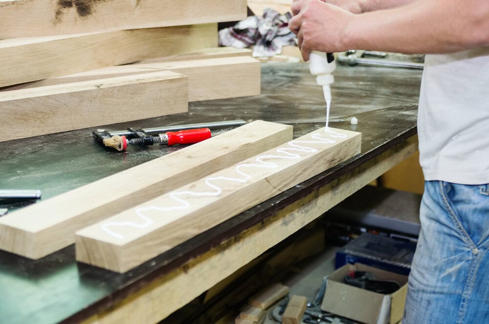 Asztalos fabútort ragaszt egy asztalos műhelyben